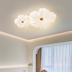 a living room with white furniture and flowers on the ceiling