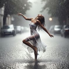 a woman is dancing in the rain with her arms spread out and head tilted to the side