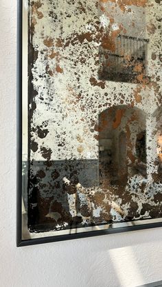 the reflection of a building in a window with rust on it's glass and paint chippings