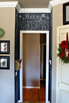 the hallway is decorated for christmas with chalkboard on the wall and wreaths hanging from the door