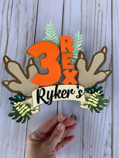 a person holding up a sign that says 3x4 and has leaves on it