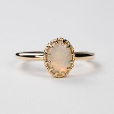 This antique style crown ring comes with a gorgeous Australian oval opal. If you want a different stone or want to add accent diamonds contact us for a quote. Details: - Default stone size is 7x5mm Australian Opal in oval shape. - Shiny finish by default. - Default width is 1.8mm at the bottom and 8.7x6.5mm at the top - Default thickness is 1.6mm at the bottom and 2mm at the top. - Contact us for quote if you want to customize this ring in any way. Thank you for shopping with Sevgi Jewelry! Heirloom Oval Opal Ring For Formal Occasions, Elegant Opal Ring With Center Stone, Elegant 14k Gold Cabochon Moonstone Ring, Elegant Oval Opal Ring In 14k Gold, Exquisite Oval Opal Ring, Elegant Oval Opal Ring For Formal Occasions, Classic Moonstone Opal Ring For Anniversary, Classic Opal Moonstone Anniversary Ring, Heirloom 14k Gold Opal Ring Oval Cabochon