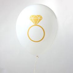 a white balloon with a yellow diamond ring on it