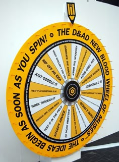 a yellow and white wheel of fortune with words written on the side, as if it was spinning