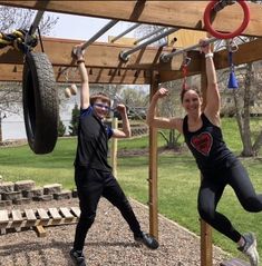 two people doing pull ups in a park