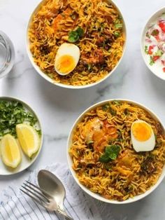 three bowls filled with different types of food on top of a white table cloth next to silverware