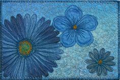 blue flowers with green centers on a light blue ground mat or wall hanging, handmade and machine stitched