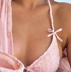 a close up of a woman wearing a pink shirt with a tie around her neck