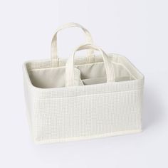 a white basket with two compartments on the bottom and one in the middle, sitting against a white background