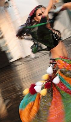 a woman in a colorful dress is dancing