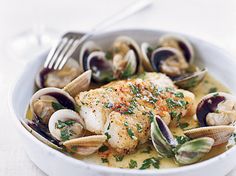 a white bowl filled with seafood and clams