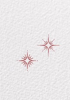 two snowflakes on white paper with red ink