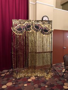 an elaborately decorated gold curtain in the middle of a room with a clock on top