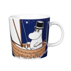 a coffee mug with a cartoon character on the front and side, sitting in a boat