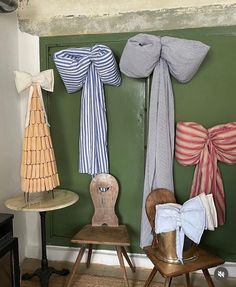 several different types of bow ties hang on the wall next to a chair and table