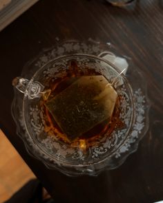 a glass bowl filled with liquid on top of a wooden table