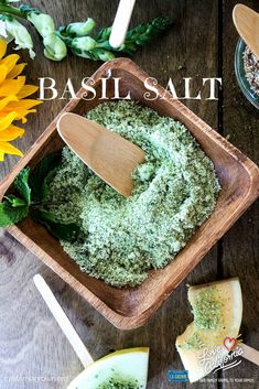 basil salt in a wooden bowl on a table next to cheese and sunflowers