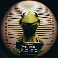 kermit the frog is holding a mug shot in front of a jail cell