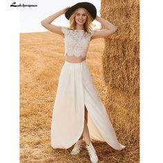 a woman in a dress and hat standing next to a hay bale with her hands on her head