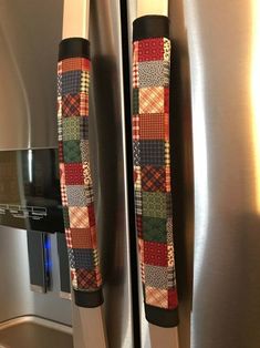 two stainless steel refrigerators with patchwork designs on the front and side door handles