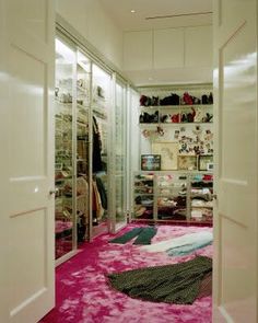 the closet is full of shoes and other items, including pink carpeted flooring