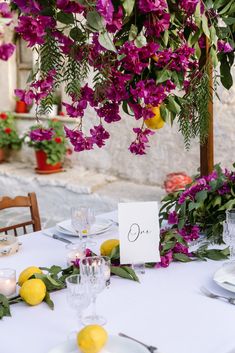 the table is set with purple flowers and lemons for an elegant wedding reception in italy