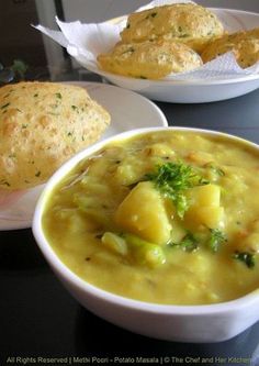 two bowls of soup with bread on the side