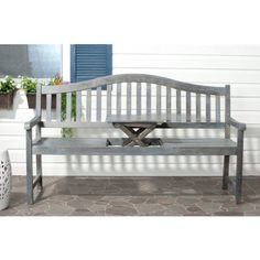 a wooden bench sitting in front of a white house