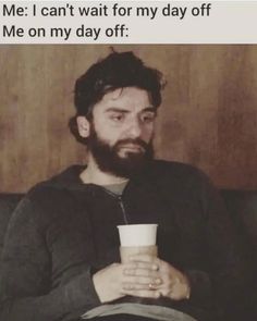 a man with a beard holding a coffee cup