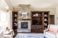 a living room filled with furniture and a fire place in front of a stone fireplace