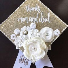 a graduation cap with flowers on it and the words thanks mom and dad written in white