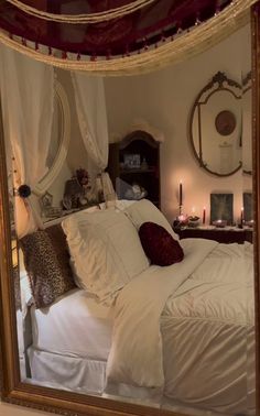 a large mirror reflecting a bed with white sheets and pillows