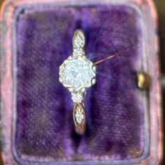 an antique diamond ring in a purple velvet box