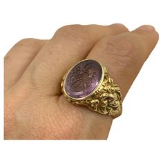 An exceptional museum quality signed Josef Seiss oval amethyst intaglio 14K yellow gold signet ring A pair of sinuously sculptural gold lions flank a superb amethyst intaglio depicting an ornate shield shaped heraldic crest with a star, moon and scorpion surrounded by intricate scrollwork and topped with an armour clad arm brandishing a scimitar sword. Antique Austrian jewels are highly prized by collectors for their high level of quality and design. Signed pieces by Josef Seiss are extremely ra Luxury Yellow Gold Amethyst Ring Oval Cabochon, Formal Carved Yellow Gold Signet Ring, Luxury Carved Yellow Gold Signet Ring, Luxury Carved Oval Signet Ring, Oval Yellow Gold Amethyst Ring With Polished Finish, Oval Amethyst Ring In Yellow Gold With Polished Finish, Luxury Oval Signet Ring With Intaglio, Formal Oval Engraved Ring With Intaglio, Luxury Oval Engraved Ring With Intaglio