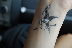 a person with a tattoo on their arm and the words get a mockingy tattoo