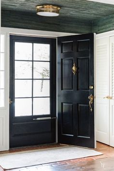 an empty room with two black doors and a light fixture on the ceiling above it