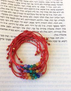 a red bracelet with beads on top of an open book