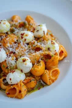 a white plate topped with pasta and cheese