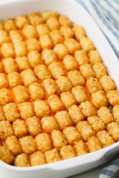 a casserole dish filled with tater tots on top of a blue and white checkered table cloth