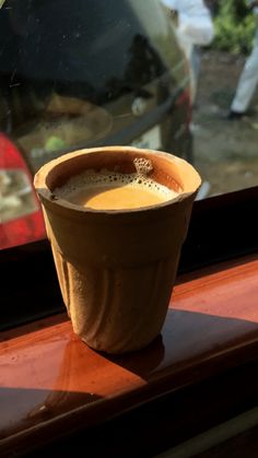 a cup of coffee sitting on top of a window sill