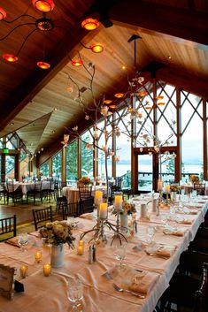 a dining room set up with candles and flowers on the table for an elegant dinner