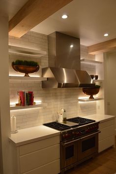 a stove top oven sitting inside of a kitchen next to a wall mounted range hood