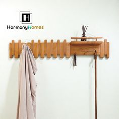 a coat rack with clothes hanging from it and a towel on the wall next to it