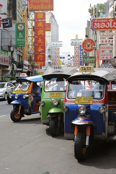 an auto rickshaw is driving down the street in front of other cars and scooters