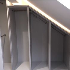 an empty walk in closet with white walls and shelves on the bottom floor, along with no doors