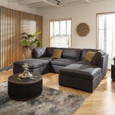 a living room filled with lots of furniture and decor on top of a hard wood floor