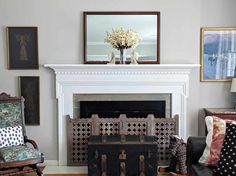 a living room filled with furniture and a fire place in front of a white fireplace