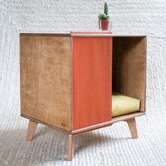 a small wooden cabinet with a plant in it's top and bottom section on the side