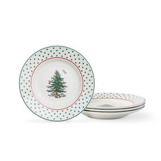 three white plates with green and red trimmings, one has a christmas tree on it