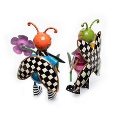 two figurines made to look like they are wearing checkered outfits and holding flowers